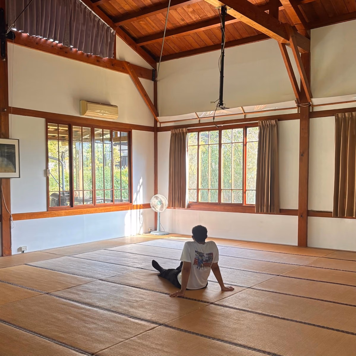 Hamza sitting in a tatami hall while travelling